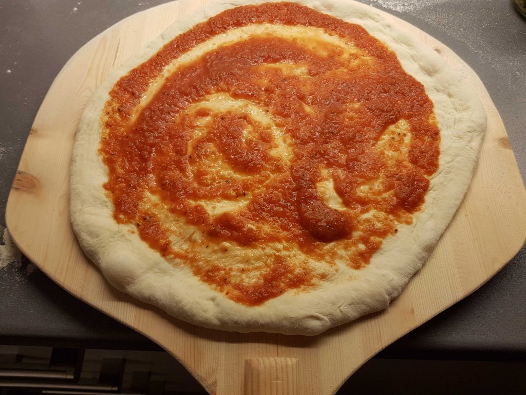 Pizza base with Neapolitan pizza tomato sauce.