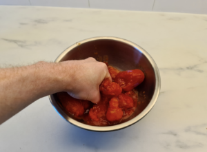 Hand-crushing San Marzano tomatoes