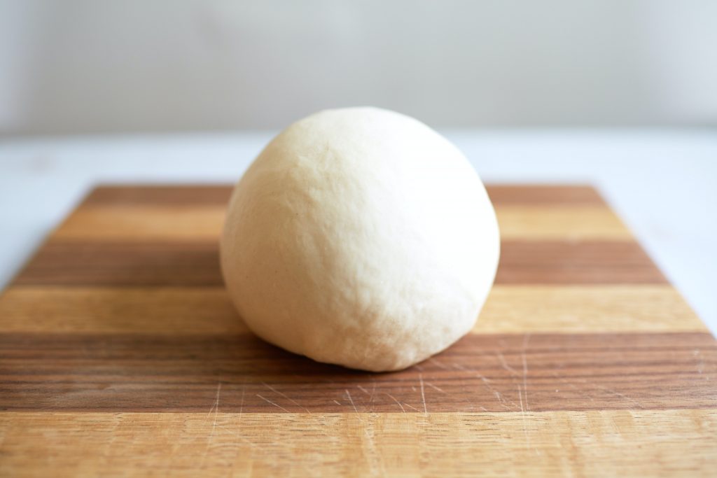 Pizza dough on cutting board