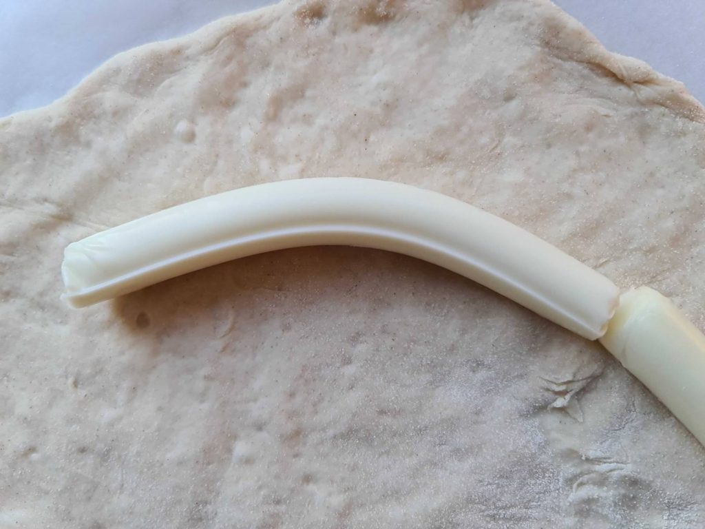 Bent string cheese for cheese crust pizza