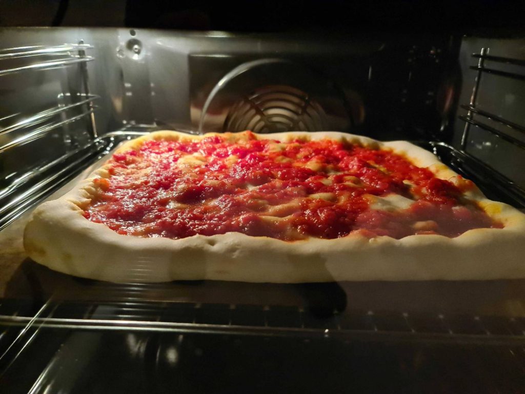 Sicilian pizza baking in the oven without toppings