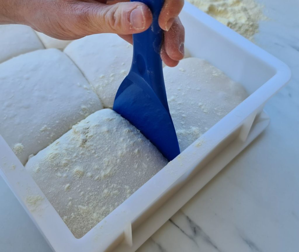 Releasing pizza dough from proofing box using a pizza spatula