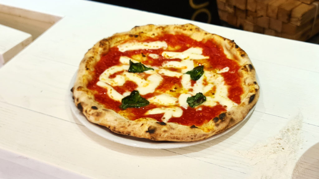 An authentic Neapolitan pizza Margherita with tomato sauce, fresh mozzarella, and basil leaves.